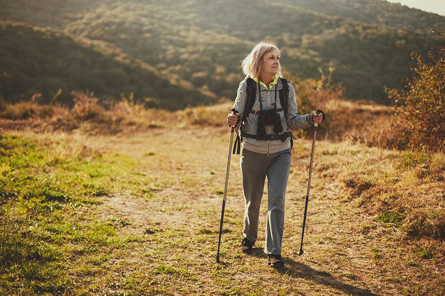 Senior woman is hiking in mountain.